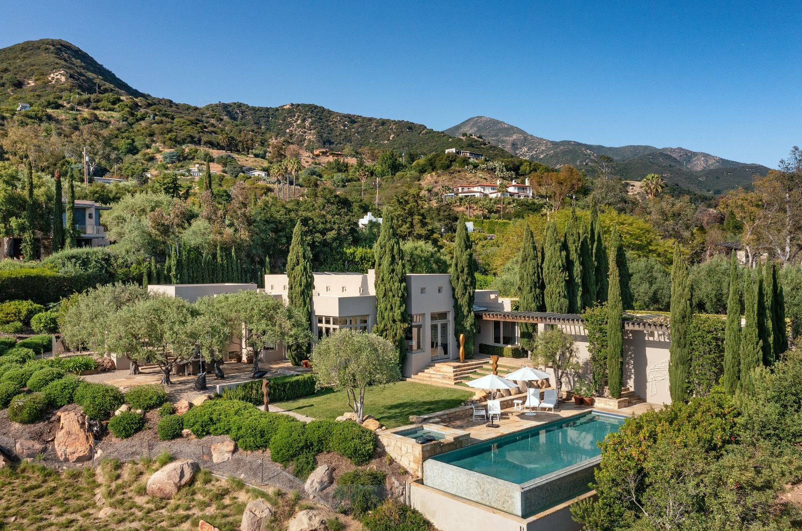 Luxury Montecito hillside estate with infinity pool, Mediterranean-style landscaping, and mountain views.